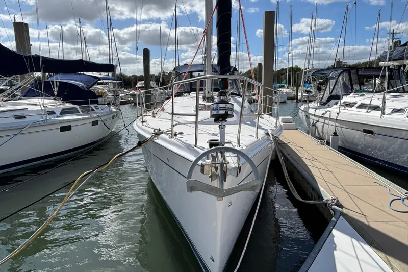 Slide: The Image of 2006 Hunter 38 sailboat docked at marina, surrounded by other boats. - 2
