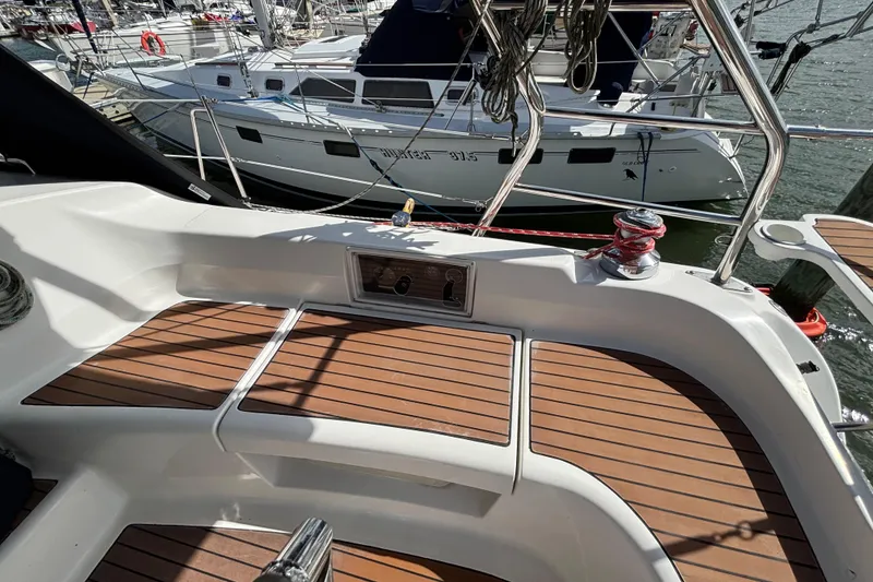 Slide: The Image of Cockpit of 2006 Hunter 38 sailboat with teak flooring and marina view. - 26