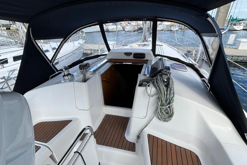 Slide: The Image of 2006 Hunter 38 sailboat cockpit with wood accents and marina view. - 33