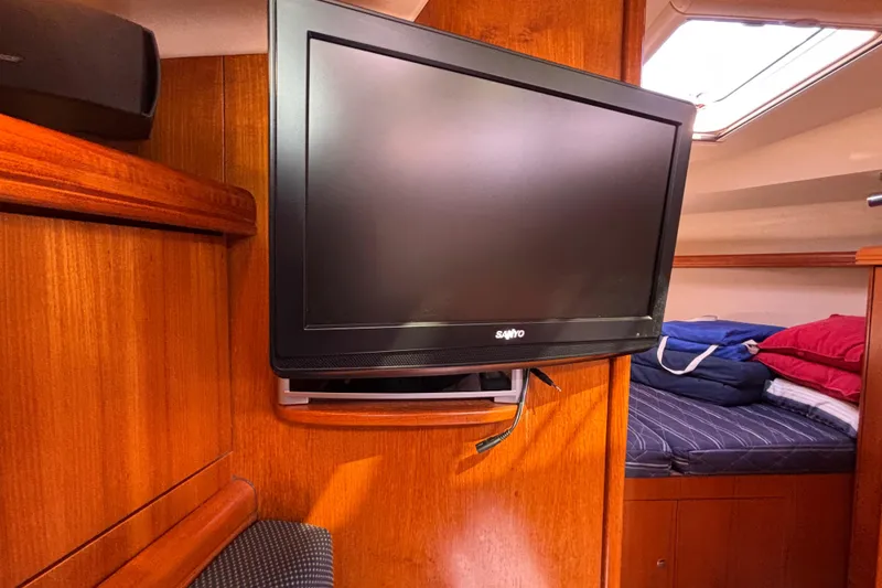 Slide: The Image of Flat-screen TV in 2006 Hunter 38 yacht interior, with wooden paneling and cozy bedding. - 37