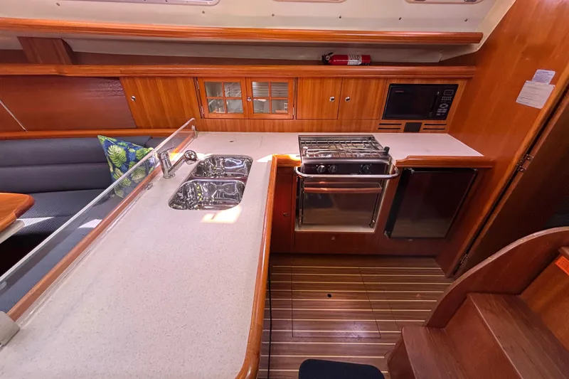 Slide: The Image of Hunter 38 yacht kitchen interior, 2006 model, featuring stove, sink, and wooden cabinetry. - 45