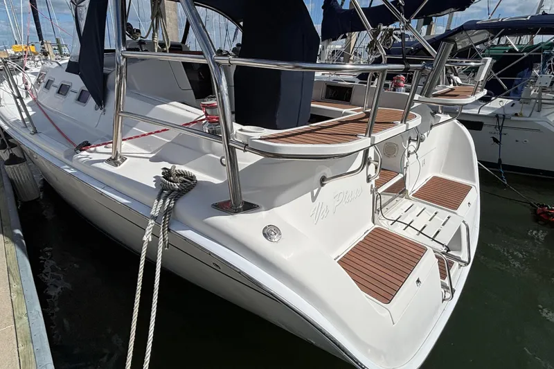 Slide: The Image of 2006 Hunter 38 sailboat docked, featuring sleek design and wooden deck accents. - 5