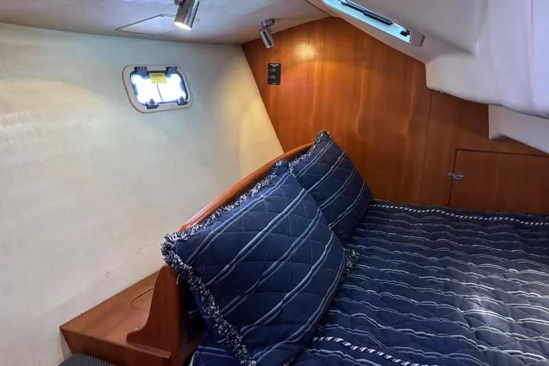 Slide: The Image of Cozy cabin interior of 2006 Hunter 38 sailboat with blue bedding and wood paneling. - 51