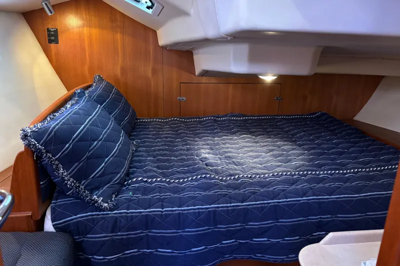 Slide: The Image of Cozy cabin interior of 2006 Hunter 38 sailboat with blue bedding and wood paneling. - 52
