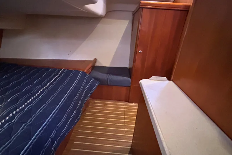Slide: The Image of Interior of 2006 Hunter 38 sailboat cabin with wooden finish and blue bedding. - 54