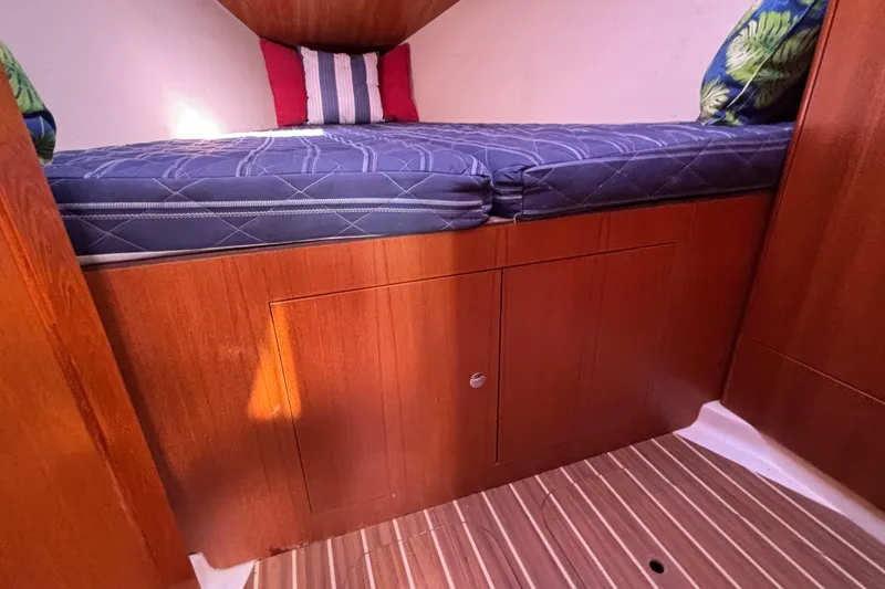 Slide: The Image of Interior cabin of 2006 Hunter 38 sailboat with wooden finish and blue mattress. - 60
