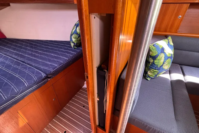 Slide: The Image of Interior of 2006 Hunter 38 sailboat with cozy bedding and tropical-themed cushions. - 63