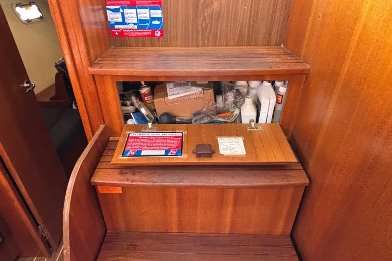 Slide: The Image of Wooden storage compartment on a 2006 Hunter 38 sailboat, containing maintenance supplies. - 65