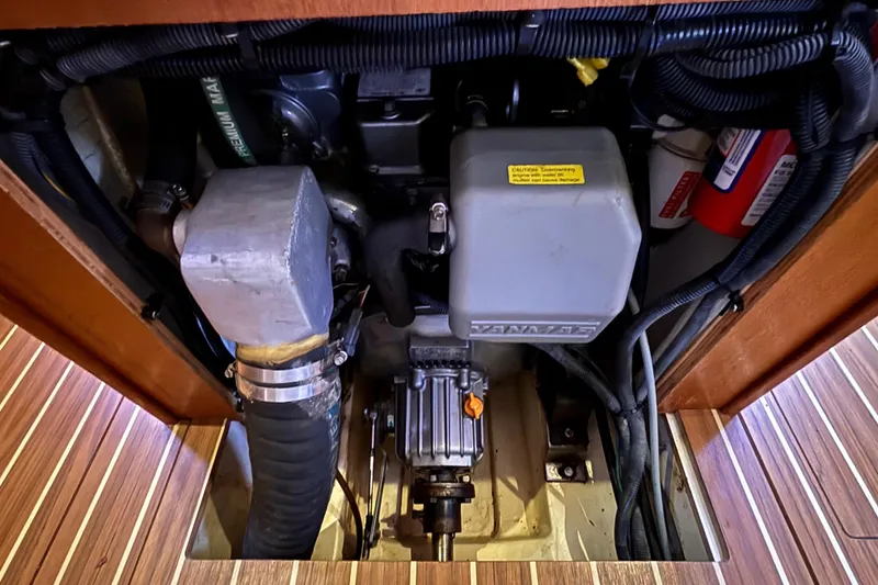 Slide: The Image of Engine compartment of a 2006 Hunter 38 sailboat, featuring mechanical components and wiring. - 67