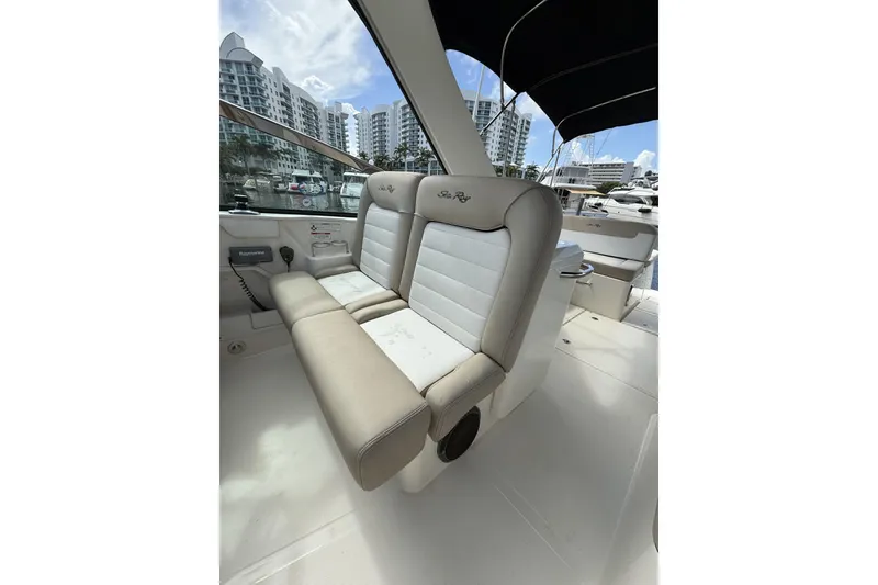 Slide: The Image of 2015 Sea Ray 370 Venture boat interior with beige seating and marina view. - 18
