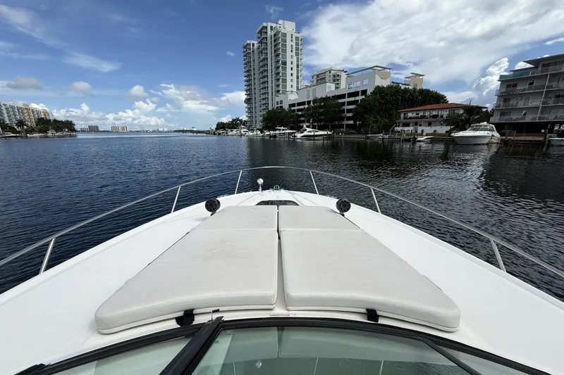 Slide: The Image of 2015 Sea Ray 370 Venture yacht cruising near waterfront buildings under a partly cloudy sky. - 21