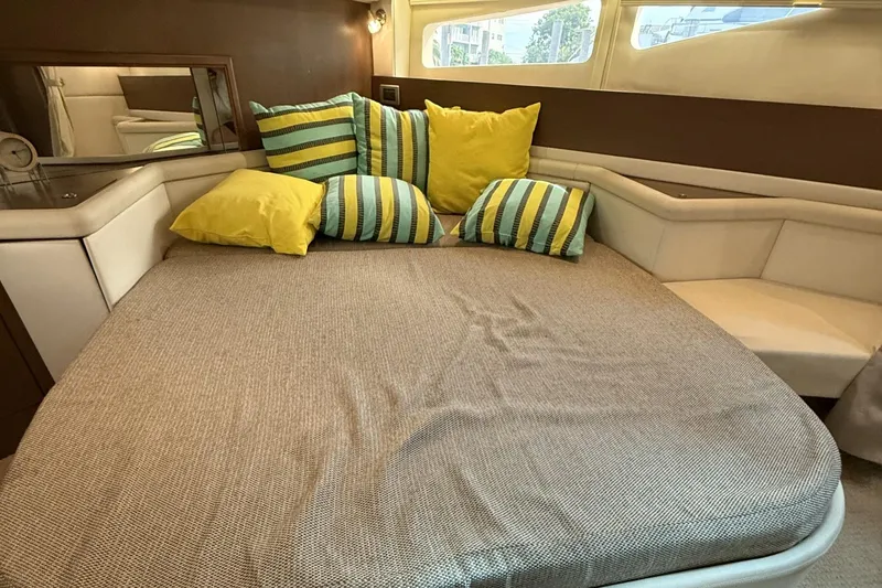 Slide: The Image of Cozy cabin interior of 2015 Sea Ray 370 Venture with striped and yellow pillows. - 26