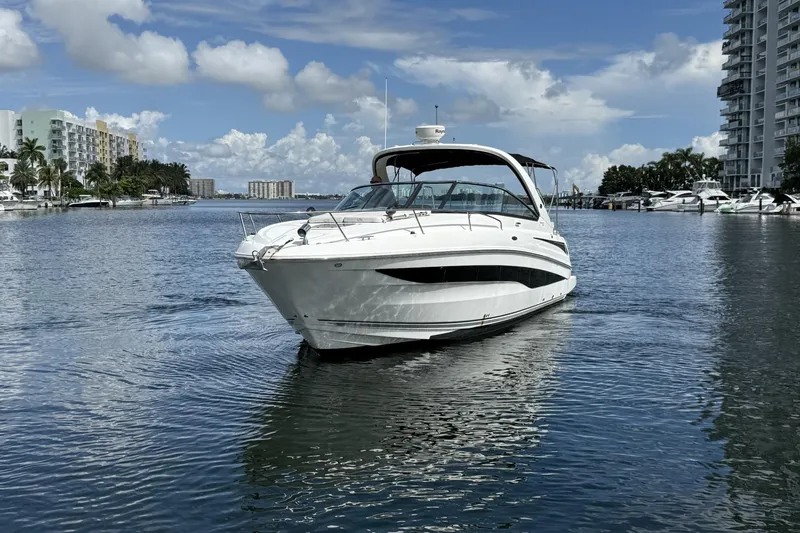 Slide: The Image of 2015 Sea Ray 370 Venture yacht cruising in a scenic waterfront setting. - 4