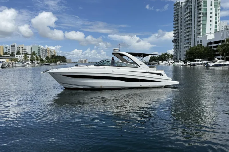 Slide: The Image of 2015 Sea Ray 370 Venture yacht on calm water near urban skyline. - 6