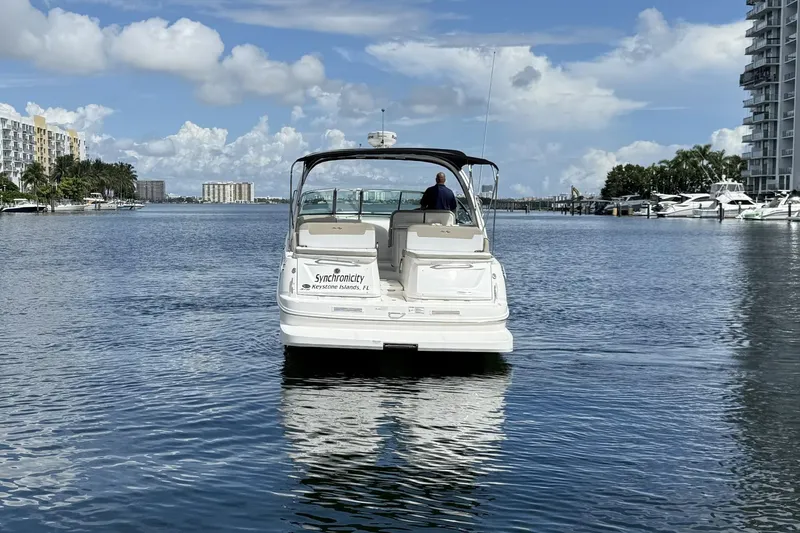 Slide: The Image of 2015 Sea Ray 370 Venture boat on calm water, cityscape in background. - 8