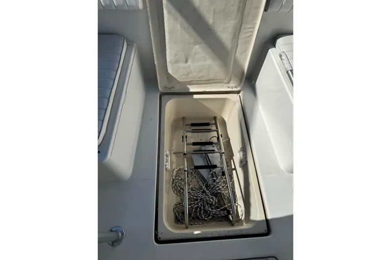 Slide: The Image of Open storage compartment on 1990 Donzi F 33 boat, containing rope and metal frame. - 18