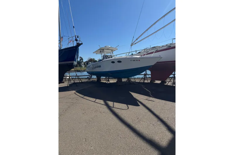 Slide: The Image of 1990 Donzi F 33 boat on stands, dockside under clear blue sky. - 4
