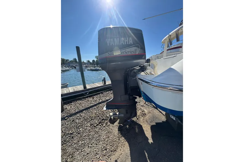 Slide: The Image of 1990 Donzi F 33 boat with Yamaha outboard motor, docked by a sunny waterfront. - 6