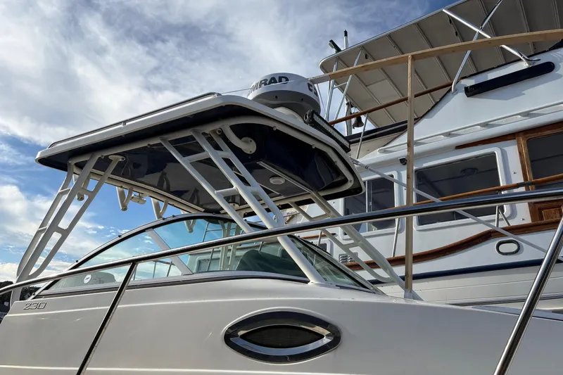 Slide: The Image of 2018 Striper 230 Walkaround boat with radar, docked under a clear sky. - 10