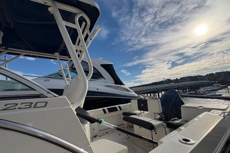 Slide: The Image of 2018 Striper 230 Walkaround boat docked under a bright sky. - 11
