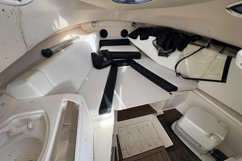 Slide: The Image of 2018 Striper 230 Walkaround cabin interior with seating, table, and storage. - 14