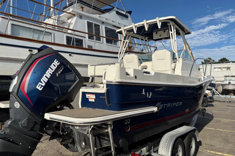 Slide: The Image of 2018 Striper 230 Walkaround boat with Evinrude engine on trailer. - 2