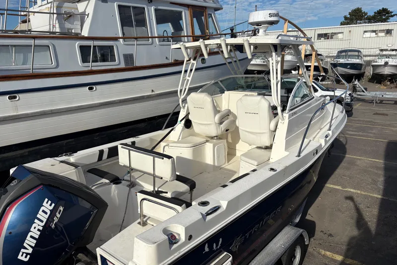 Slide: The Image of 2018 Striper 230 Walkaround boat with Evinrude engine, docked in a marina. - 5