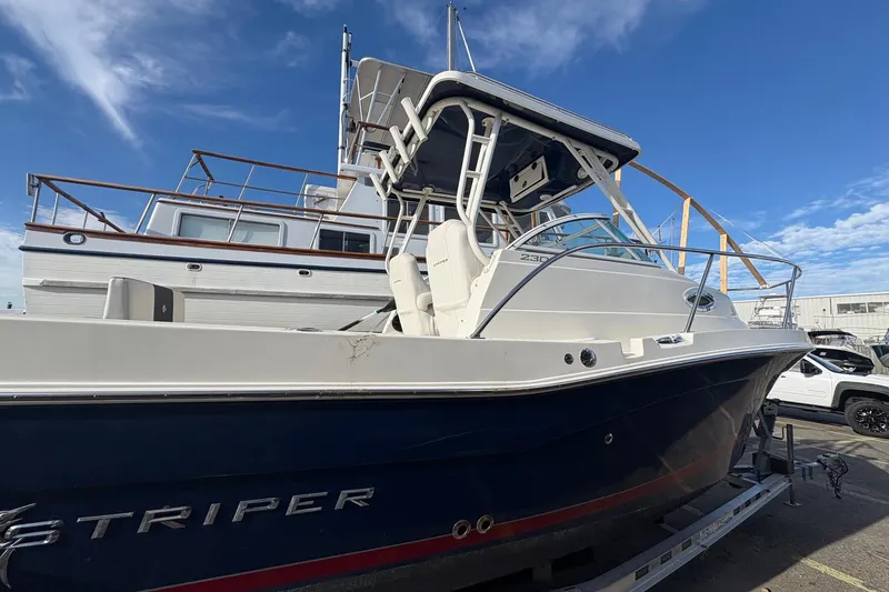 Slide: The Image of 2018 Striper 230 Walkaround boat on trailer under blue sky. - 6