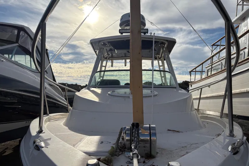 Slide: The Image of 2018 Striper 230 Walkaround boat docked under a cloudy sky. - 8