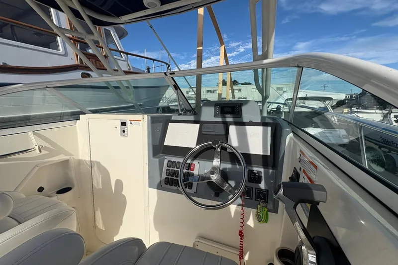 Slide: The Image of 2018 Striper 230 Walkaround boat cockpit with steering wheel and control panel. - 9