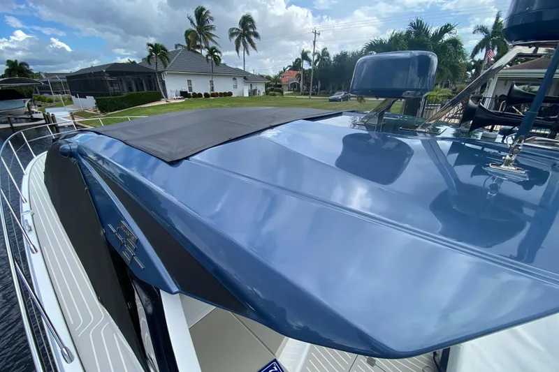 Slide: The Image of 2021 Azimut Atlantis 45 yacht with sleek blue exterior, docked near palm trees. - 10