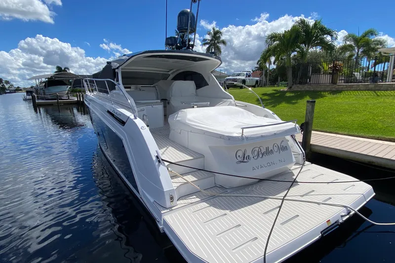 Slide: The Image of Azimut Atlantis 45 yacht docked, 2021 model, sunny day, lush greenery, calm water. - 2