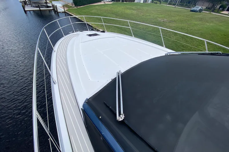 Slide: The Image of Azimut Atlantis 45 yacht deck, 2021 model, docked by a grassy shoreline. - 7