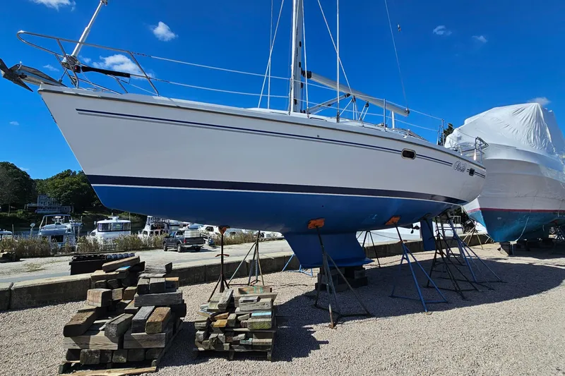 Slide: The Image of 2007 Catalina 350 sailboat on stands in a boatyard under a clear blue sky. - 1