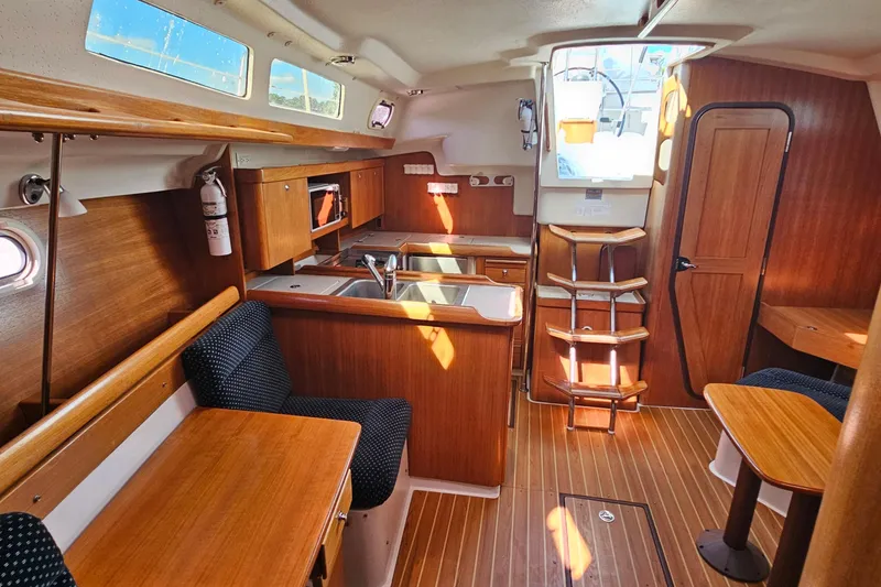 Slide: The Image of Interior of 2007 Catalina 350 sailboat with wood finish and compact kitchen area. - 13