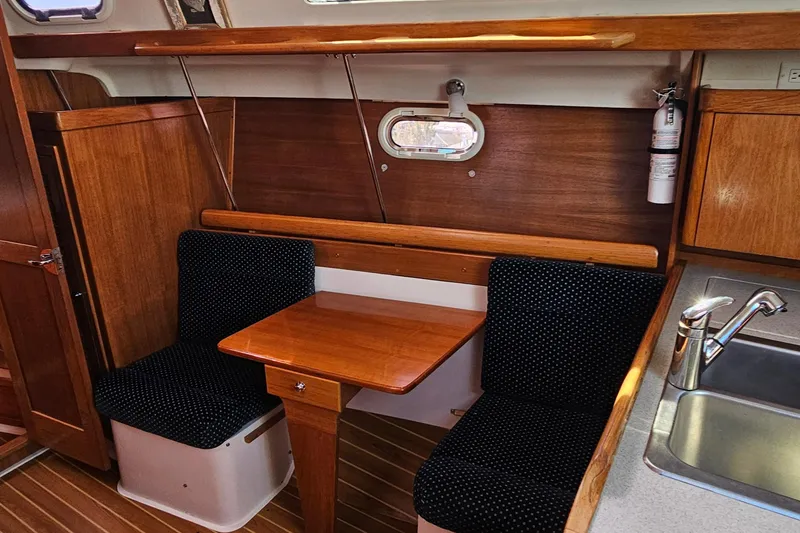 Slide: The Image of 2007 Catalina 350 yacht interior with wooden dining area and compact kitchen sink. - 15