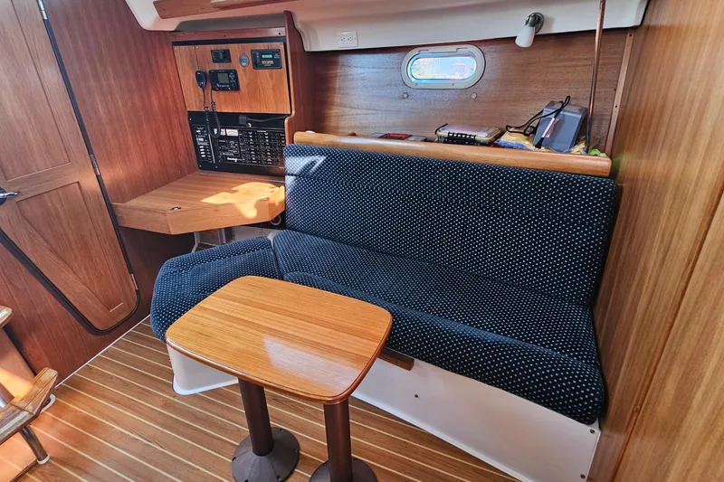 Slide: The Image of Interior of 2007 Catalina 350 sailboat with wooden paneling and cozy seating area. - 17
