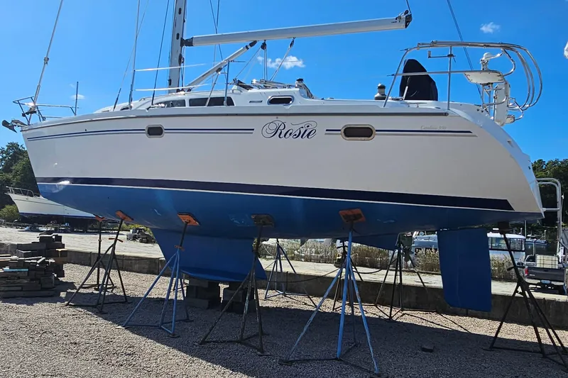 Slide: The Image of Catalina 350 sailboat from 2007 on stands, named "Rosie," in a boatyard. - 2