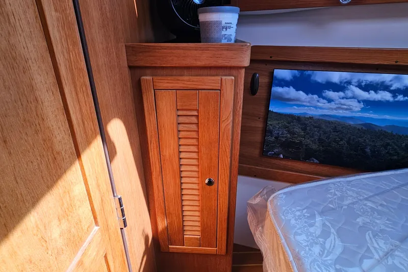 Slide: The Image of Interior of a 2007 Catalina 350 sailboat with wooden cabinetry and scenic window view. - 21