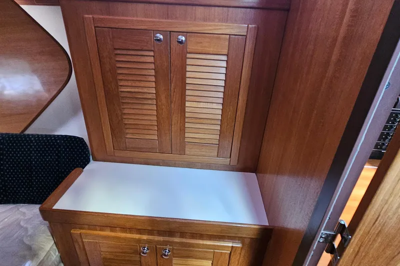 Slide: The Image of Wooden cabinetry inside a 2007 Catalina 350 sailboat, featuring a sleek, polished finish. - 26