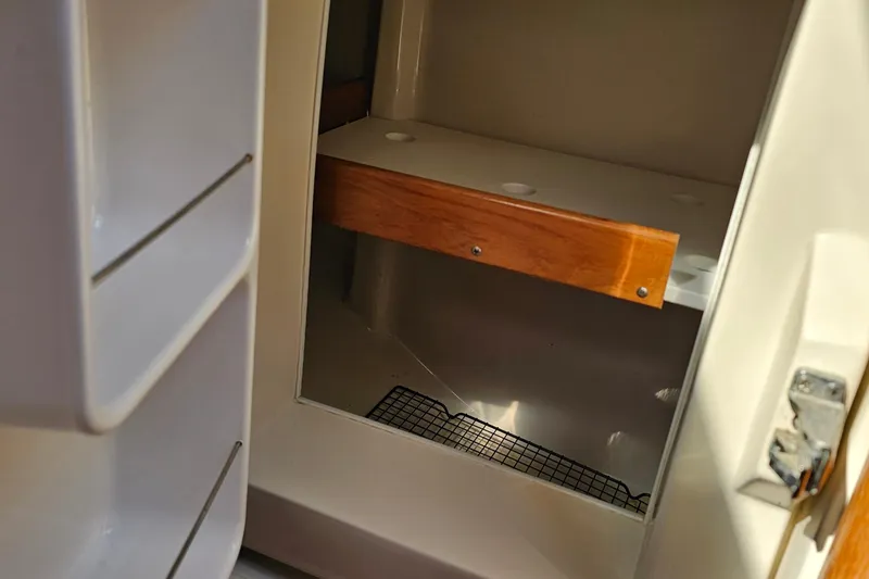 Slide: The Image of Interior storage compartment of a 2007 Catalina 350 sailboat with wooden shelf. - 27