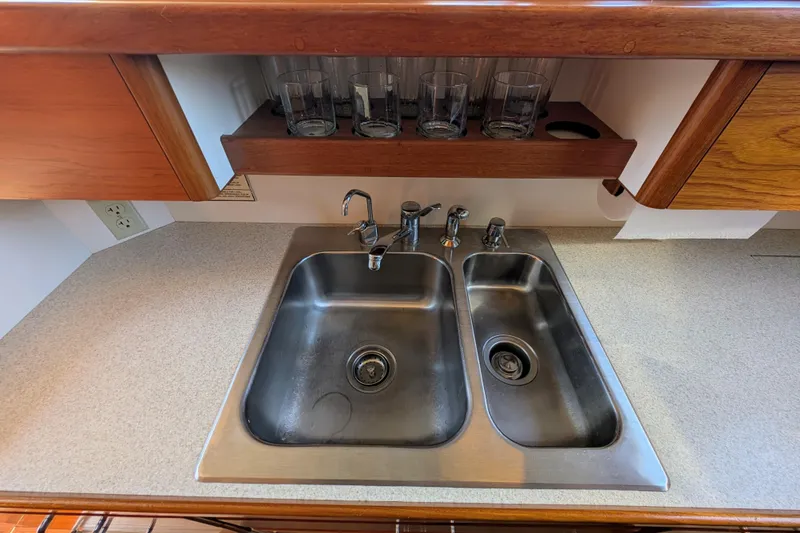 Slide: The Image of Double stainless steel sink in a Dettling 51 yacht kitchen, 2001 model, with wooden cabinetry. - 32