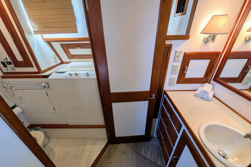 Slide: The Image of Laundry and bathroom area in a 2001 Dettling 51 yacht, featuring wood accents and modern amenities. - 36