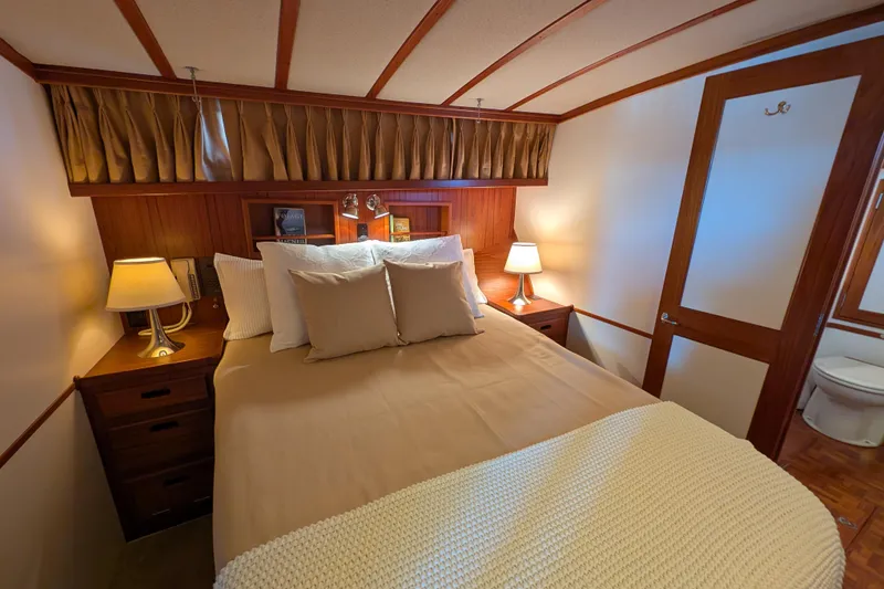 Slide: The Image of Cozy bedroom interior on 2001 Dettling 51 yacht with warm lighting and elegant wood finishes. - 41