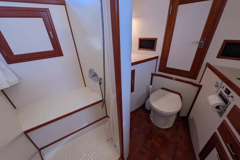 Slide: The Image of Bathroom interior of 2001 Dettling 51 yacht, featuring shower and toilet with wood accents. - 47
