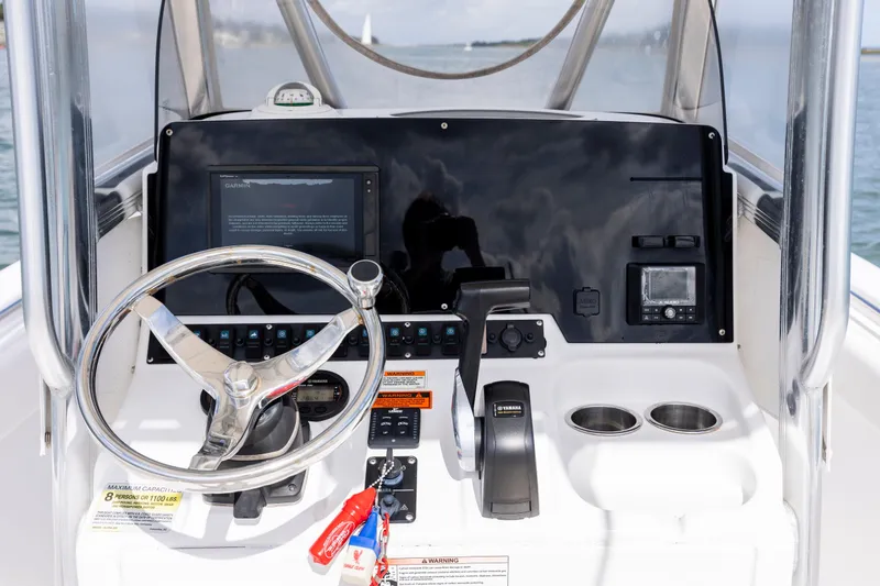 Slide: The Image of 2020 Sea Hunt Ultra 225 boat dashboard with steering wheel and navigation controls. - 16