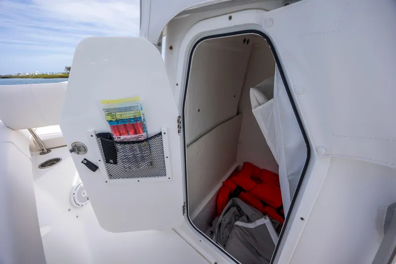 Slide: The Image of Storage compartment on a 2020 Sea Hunt Ultra 225 boat with safety gear inside. - 17