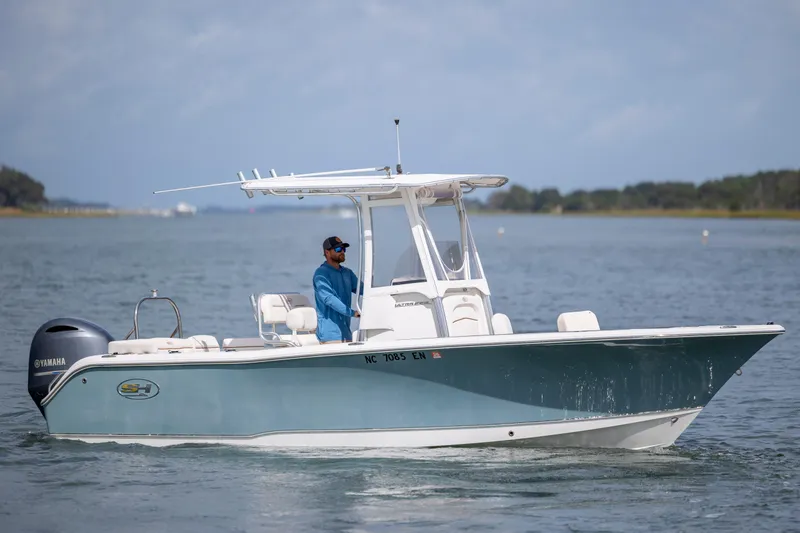 Slide: The Image of 2020 Sea Hunt Ultra 225 boat cruising on a calm waterway. - 2