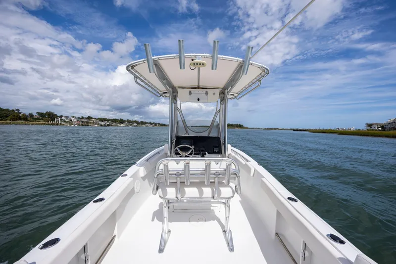 Slide: The Image of 2020 Sea Hunt Ultra 225 boat on calm water under a partly cloudy sky. - 21