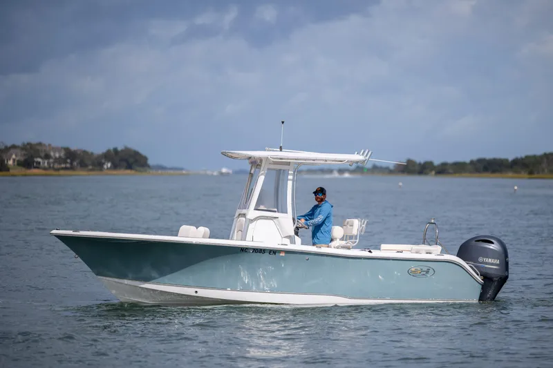 Slide: The Image of 2020 Sea Hunt Ultra 225 boat on water with Yamaha engine, clear sky background. - 8